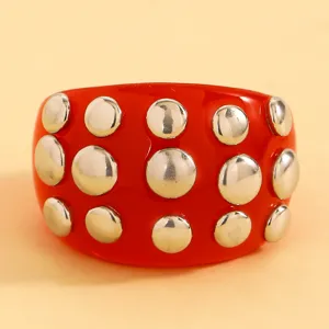 Red resin cuff bracelet featuring metallic silver dome studs for a bold punk style.