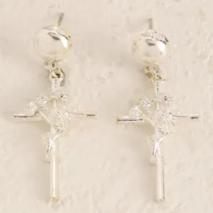 Gros plan détaillé de boucles d'oreilles croix épines roses argent style gothique.