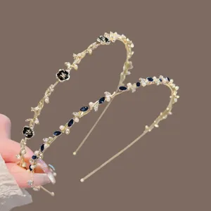 Bandeau de cheveux fin et élégant en métal doré avec perles et fleurs noires pour un style chic.