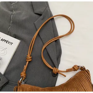 Detailed close-up view of a brown suede fringe shoulder bag with stylish knotted strap design.