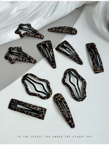 Close-up detail shot of cute retro leopard print hair clips, aesthetic flat lay display.