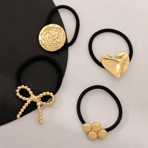 Set of 4 gold metal charm black hair ties featuring heart, bow, and disc designs for women.