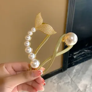 Gold metal hair claw clip with elegant pearls and mermaid tail design for stylish hairstyles.