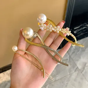 Detailed view of elegant metal hair clips adorned with glossy artificial pearls for stylish hairstyles.