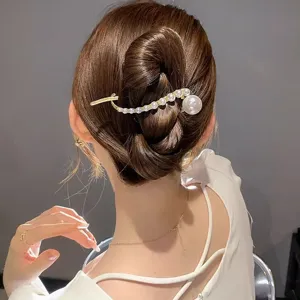 Vista detallada de un elegante pasador de pelo con perlas para peinados recogidos chic.