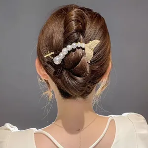 Primer plano de elegante pinza de pelo de sirena con perlas para elegantes recogidos.