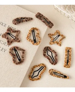 Gros plan détaillé de jolies pinces à cheveux en peluche motif léopard et formes variées.