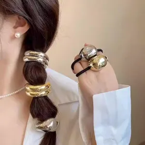 Close-up detail of metallic geometric hair tie, shining gold and silver finish for ponytails.