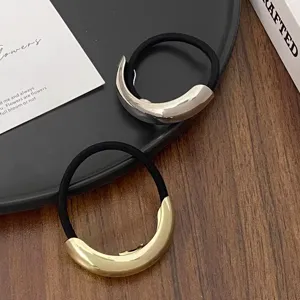 Detailed closeup of minimalist metal geometric hair ties in elegant gold and silver.