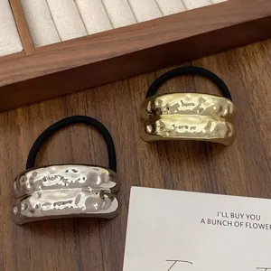 Detailed view of minimalist metal geometric hammered hair ties in gold and silver, elegant ponytail holder.