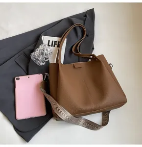 Stylish brown leather bucket bag with patterned strap, elegant everyday shoulder handbag.