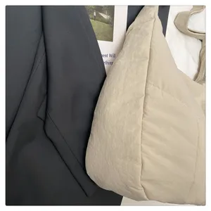 Close-up detail view of the casual minimalist beige slouchy shoulder bag and crossbody tote.