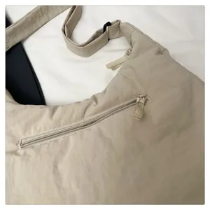 Beige nylon hobo shoulder bag detail view, casual minimalist crossbody bag with zipper pocket.