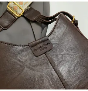 Minimalist brown leather shoulder bag with wide strap, trendy daily crossbody bag for women.
