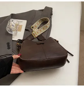 Detailed view of the dark brown women's stylish crossbody shoulder bag with wide strap.