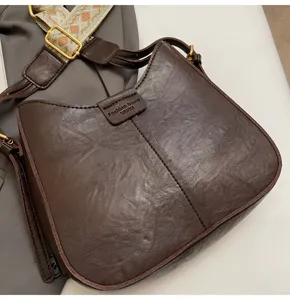 Brown PU leather shoulder crossbody bag with wide strap and metal buckle, detailed view.
