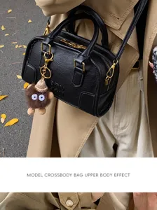 Stylish black leather women handbag with top handle and crossbody strap for daily wear.
