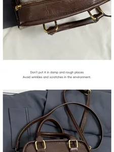 Brown leather handbag detail showing fine texture, metal hardware and strap design.
