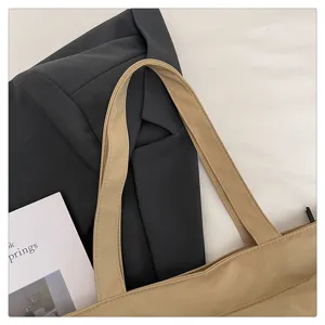 Vista detallada del bolso tote minimalista beige para mujer, textura de material de calidad y asas.