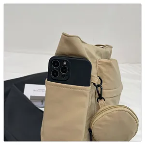 Detalle del elegante bolso de hombro caqui para cercanías con bolsillo exterior y pequeño monedero.