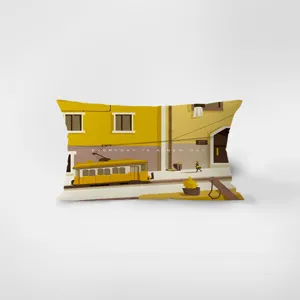 Vista detallada del cojín rectangular de terciopelo amarillo con una ilustración urbana.