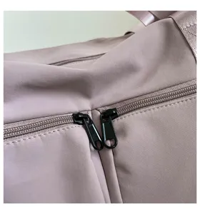 Close-up detail of smooth fabric and durable zippers on a stylish travel duffel bag.