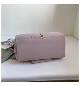 Detail view of large capacity solid color puffer travel yoga duffel bag in soft pink.