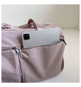 Detail shot showing front zipper pocket capacity of the solid color travel duffel bag.