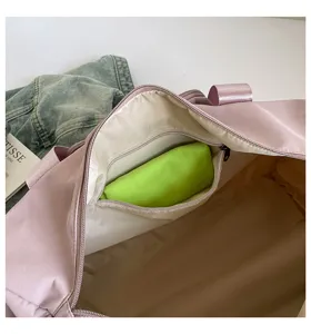 Detailed view of the pink travel duffel bag interior zipper pocket with green pouch insert.
