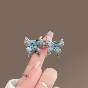 Dettaglio fibbia stringi vita a farfalla blu, clip regolatore vita in metallo per pantaloni larghi.