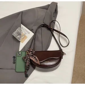 Stylish brown leather saddle bag for women, chic crossbody shoulder bag with cute silk scarf.