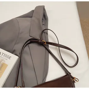 Detailed view of brown leather saddle bag with adjustable strap and metal hardware.