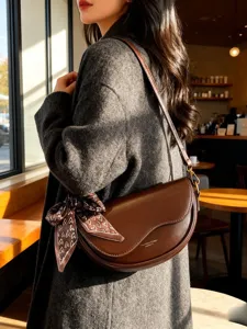 Chic brown leather saddle bag for women, stylish underarm shoulder bag with a cute scarf.