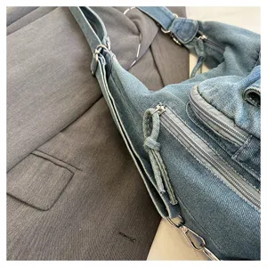 Denim shoulder bag detail view, casual crossbody bag with metal zippers and multi pockets.