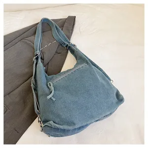 Detailed view of casual denim shoulder bag and backpack with metal hardware and zippers.