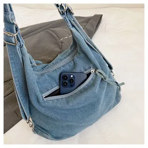 Casual denim shoulder bag with multi-way straps and convenient front zipper pocket.