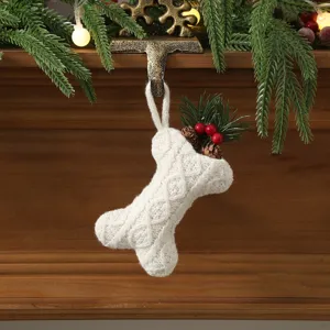 Close-up of white cable-knit bone Christmas stocking ornament with pinecones and berries.