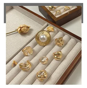 Detailed closeup of stylish gold open rings featuring pearls and vintage textured metal finish.