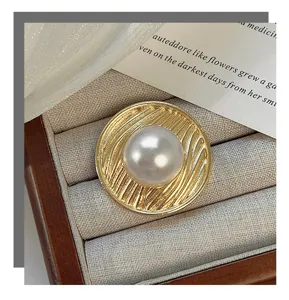 Detailed view of vintage pearl ring in jewelry box, showing textured metal and smooth pearl.