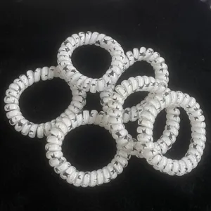 Elastici per capelli a filo telefonico con stelle bianche e nere, dettaglio per coda di cavallo.