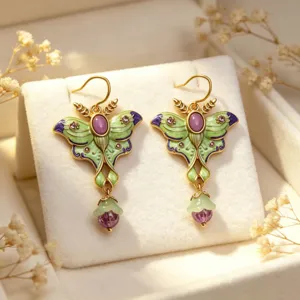 Detailed view of vintage enamel moth earrings with purple gemstones and delicate tassels.