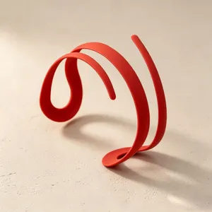 Close-up detail of the modern minimalist red curved cuff bracelet design, sleek and unique styling.