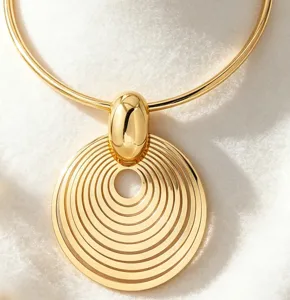 Exquisite gold-tone metal statement choker necklace featuring a bold concentric circle pendant.