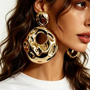 Large gold hammered hollow statement earrings for women, chic avant-garde modern jewelry.
