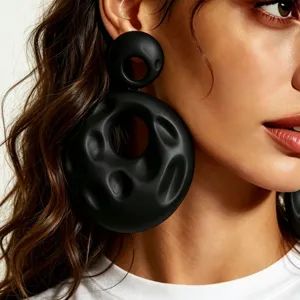 Minimalist black avant-garde statement earrings, irregular hammered hollow drop design.