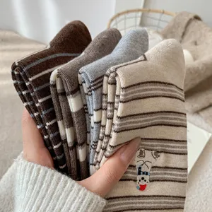 Close-up view of winter cozy striped socks with cute polar bear embroidery, soft warm fabric.