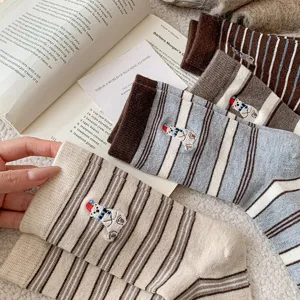 Detailed view of cute polar bear embroidered winter warm striped wool socks, soft cozy fabric.