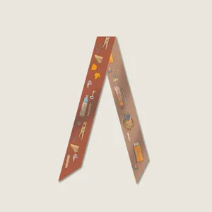 Close-up detail of a narrow printed twilly scarf with retro stationery illustrations.