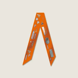 Detailed view of an orange silk twilly scarf with cute printed motifs, perfect for bag handles.
