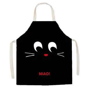 Black cartoon cat face kitchen apron with adjustable straps for cooking and baking tasks